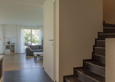 Eingangsbereich mit Treppe und Blick in den Wohnbereich, Einfamilienhaus im Steinhof, Aeschi