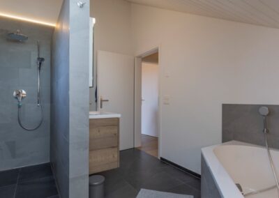 Badezimmer mit Dusche und Badewanne im Einfamilienhaus im Steinhof, Aeschi